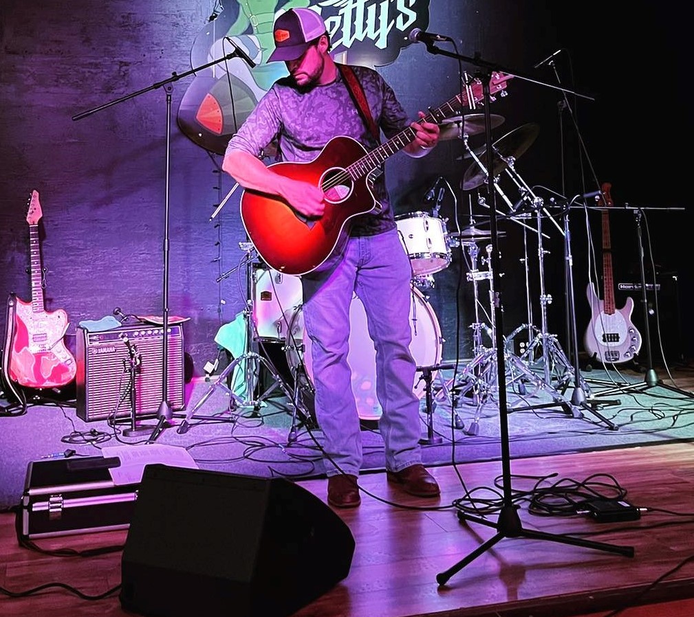 George Maddox on stage playing guitar George Maddox on stage playing guitar